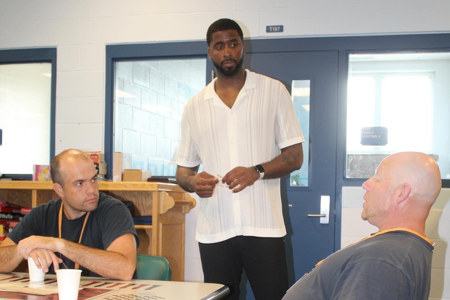 Brett Hollins speaking with participants inside a facility