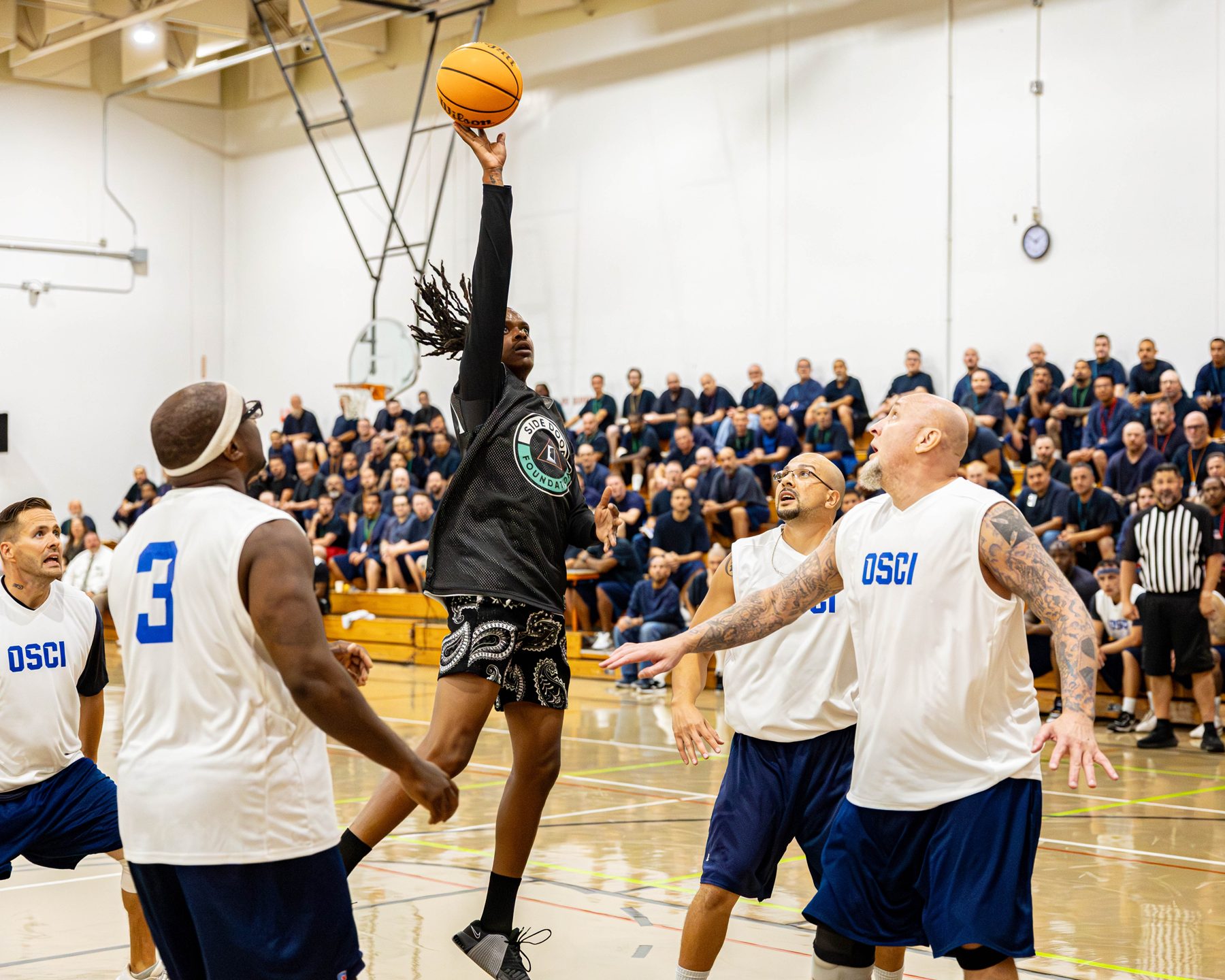 A community basketball game inside a correctional facility gym